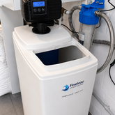 Waterverzachter met besturing Fleck 5600 SXT wit op de achtergron is een filterhuis te zien.